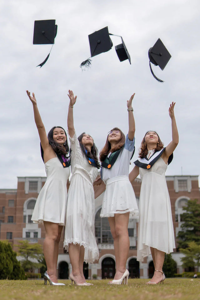 Four female graduates celebrating success stories of successful entrepreneurs and productivity insights
