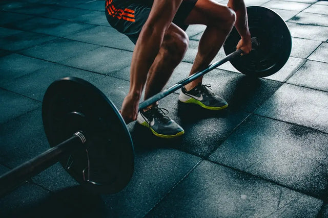 Athletic shoes gripping a loaded barbell symbolizing physical health in today’s fast-paced world.