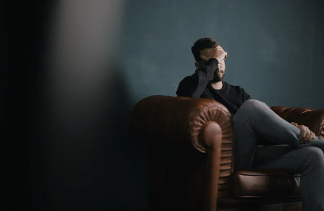 Man sitting on a brown leather armchair representing transformation of fear in hustle culture