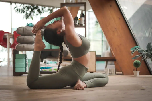 Individual practicing King Pigeon Pose on a mat as part of a transformative fitness journey.