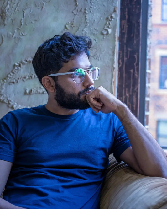 Bearded individual in blue t-shirt reflecting on the transformative power of Christian work ethic.