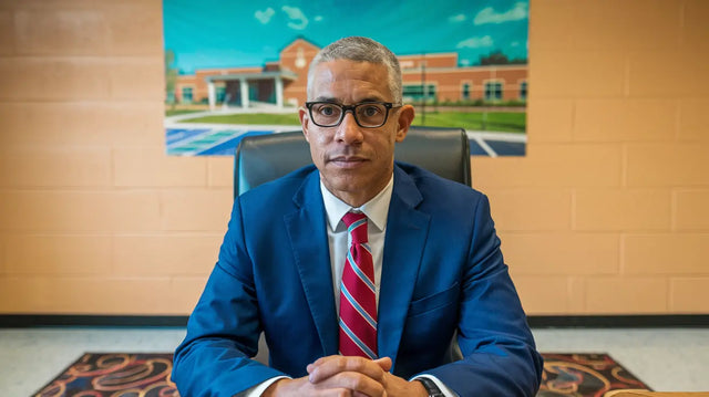 Professional in navy suit illustrating transformative power in educational landscape.