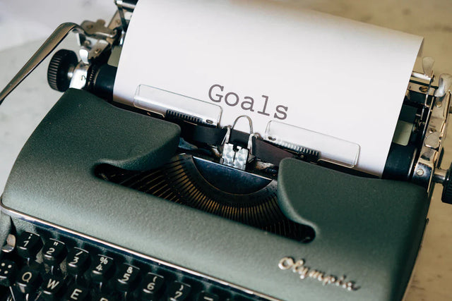 Dark green vintage typewriter with white paper symbolizing core values and value-aligned goals