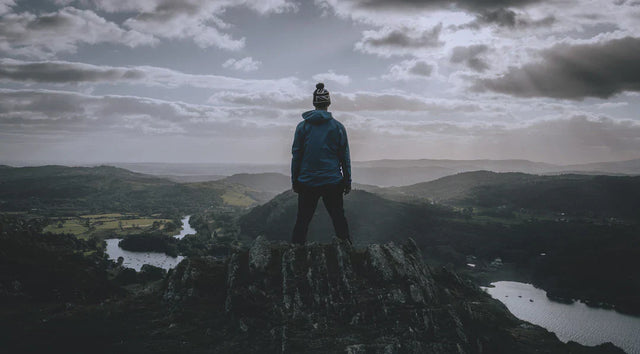 Person standing on mountain peak symbolizing growth mindset and mindfulness techniques
