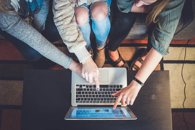 Hands typing on a laptop, illustrating innovative marketing strategies for school’s vision.