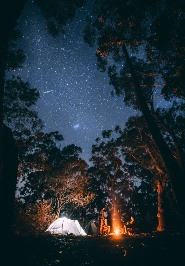 Vibrant campsite under a starry night sky illustrating breaking free from comfort zones