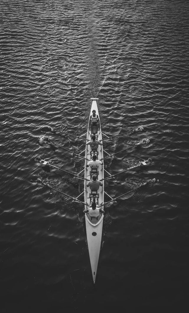 Racing scull with rowers demonstrating teamwork in a transformative student experience.