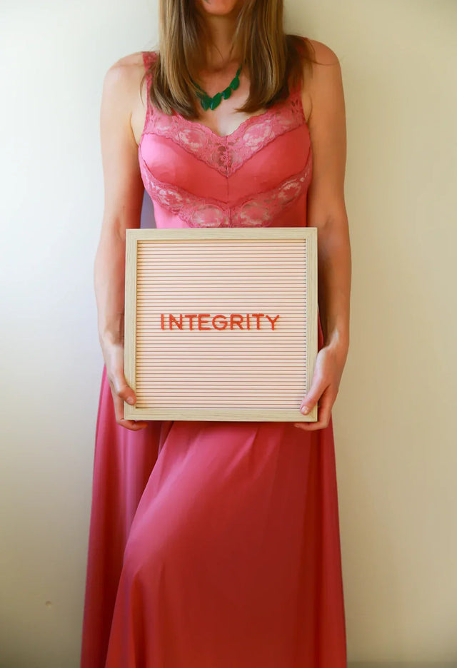 Pink lace dress with green necklace symbolizing ethical standards in e-commerce success