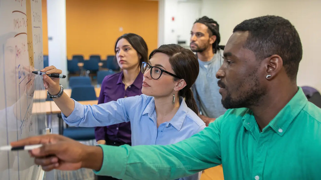 People examining a wall during a meeting, showcasing Avodah Dynamics services.
