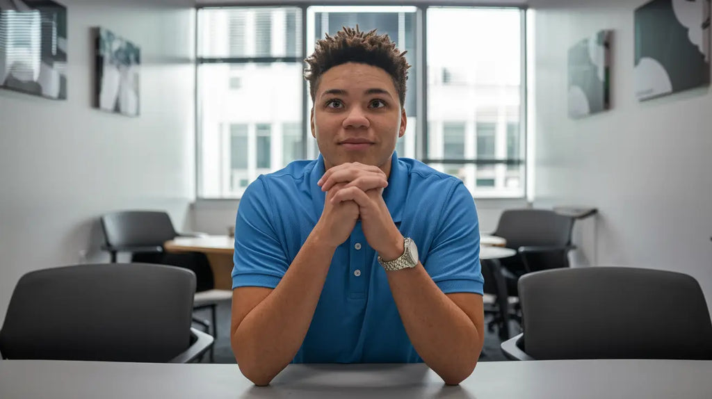 Individual in bright blue polo shirt exemplifies hustle culture at career development table.