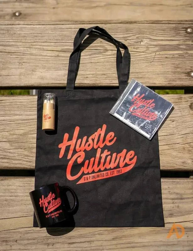 Black bag featuring a Hustle Culture book, a bottle of beer, and color pencils