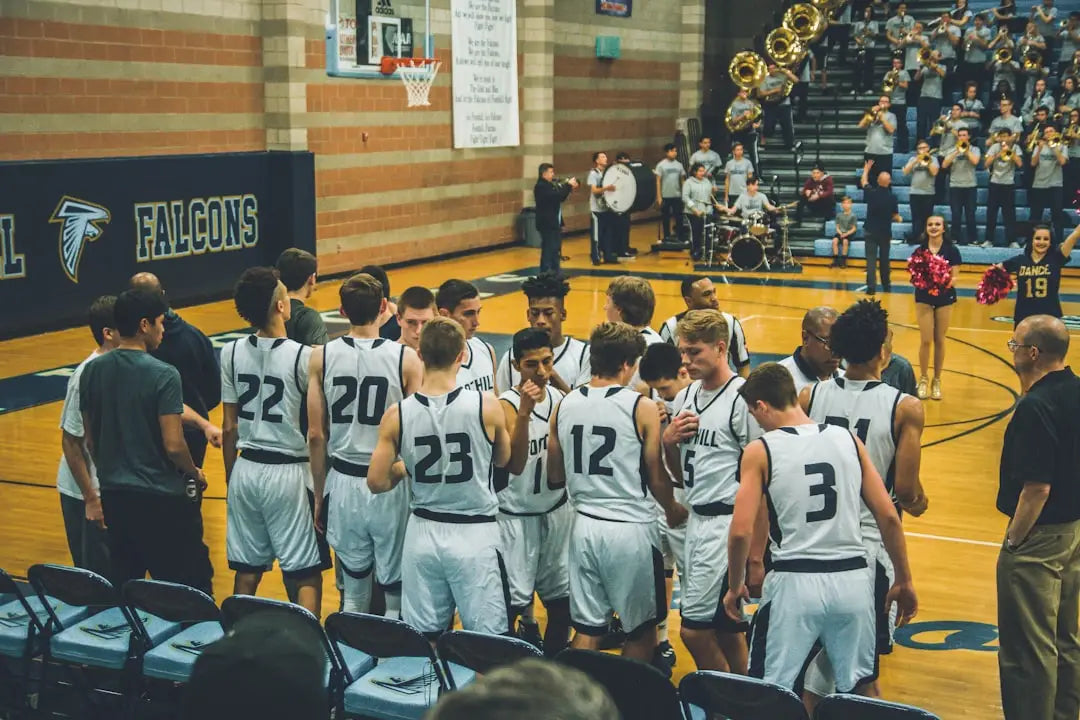 Basketball team in a huddle demonstrating teamwork for stress management techniques