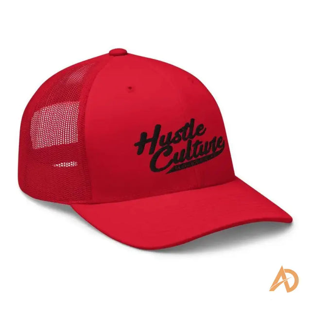 Close up of a red trucker cap featuring hustle culture embroidery design