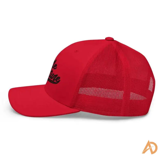 Red trucker cap with black logo showcasing hustle culture style and design