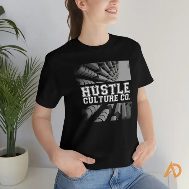 Woman in a black Hustle Culture streetwear tee by Andreas Sturmfels with a white logo