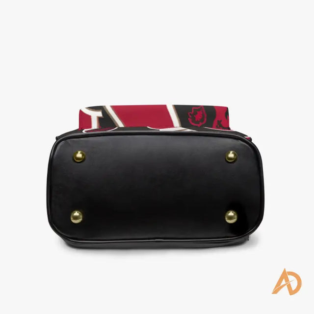 Black handbag featuring gold-toned studs and red trim, ideal for the Hustle Paisley Backpack