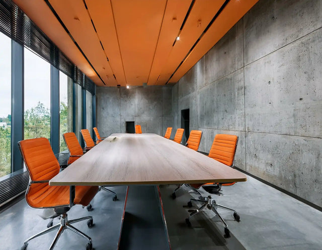 Modern conference table with orange office chairs.