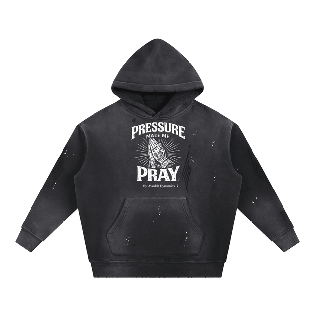 Front view of the white Pressure Made Me Pray Hoodie by Avodah Dynamics, featuring distressed typography and praying hands graphic.