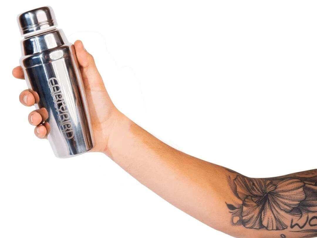 Silver cocktail shaker with floral tattooed arm for perfect morning routine