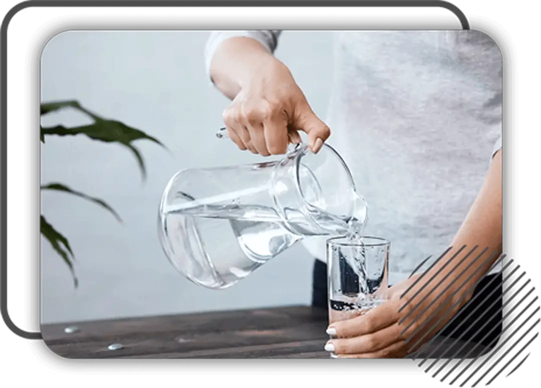 Clear glass pitcher pouring water into matching glass for perfect morning routine